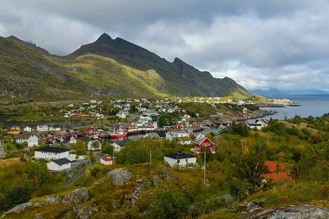 九月的 Sørvågen 村庄和港湾，山坡带有秋季植被色彩